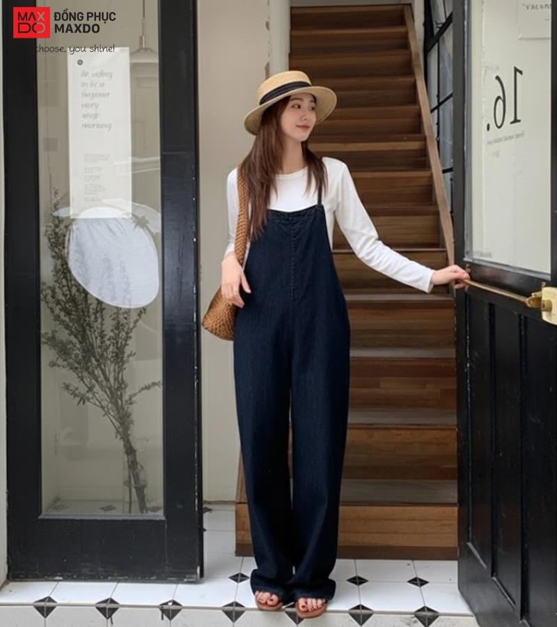 Áo thun dài tay kết hợp với quần yếm vải kết hợp nón và túi cói tạo nên tổng thể dạo phố đầy phong cách.